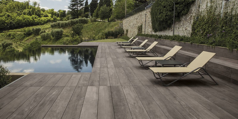 Gres porcelánico efecto madera, junto a una piscina infinita