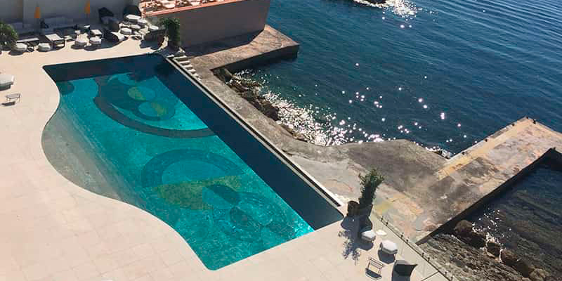 vista dron de una piscina junto al mar, con revestimiento mediante metalización en frío